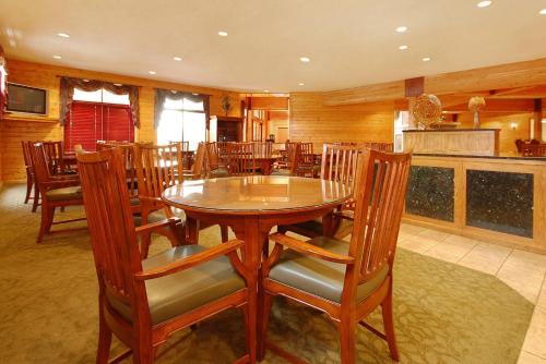 a dining room with a wooden table and chairs at Norfolk Lodge & Suites, an Ascend Collection Hotel in Norfolk