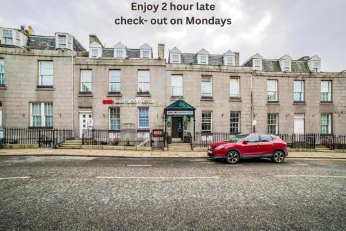 a red car parked in front of a building at Brentwood Aberdeen City Centre near Union Street in Aberdeen