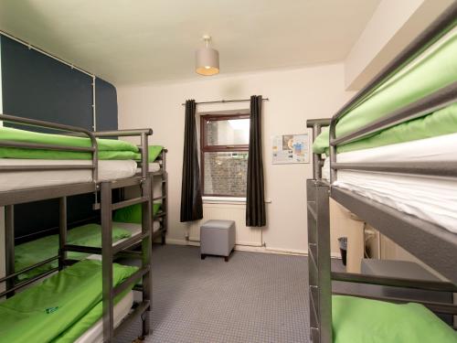 a room with three bunk beds and a window at YHA Hathersage - Partner in Hathersage