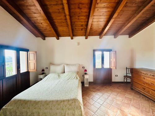 Un dormitorio con una cama y un techo de madera. en Tenute Pacelli - Azienda Agricola, en Malvito