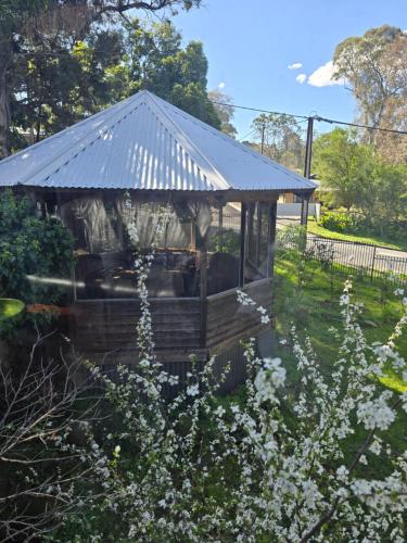 a gazebo with a metal roof in a garden at Nottingham way Homestay in Blackwood