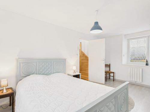 a white bedroom with a large bed and a staircase at Maison pour 7 avec jardin - Quartier paisible in Plouguerneau