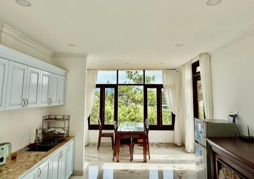 a kitchen with a table and chairs and a window at Khu ngỉ dưỡng Tâm Anh Đà Lạt in Ấp Man Ling
