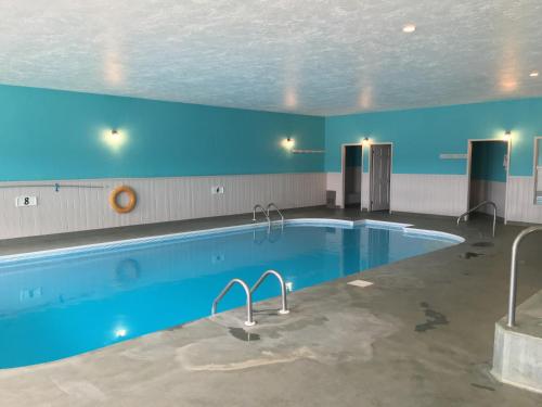 a large swimming pool in a building with a blue ceiling at Fairway Inn in Sussex