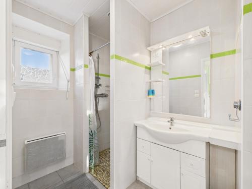a white bathroom with a sink and a mirror at Idéal pour 2 en pleine campagne avec jardin in Plouguerneau