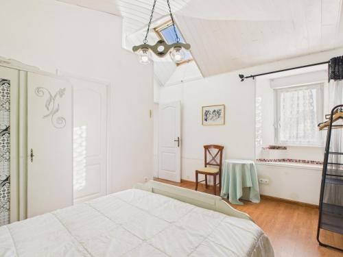 a white bedroom with a bed and a table at Idéal pour 2 en pleine campagne avec jardin in Plouguerneau