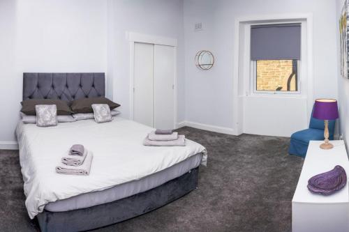 Buccleuch Bliss في هاويك: غرفة نوم بها سرير كبير وكرسي أزرق