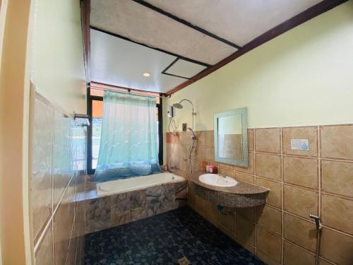 een badkamer met een bad, een wastafel en een spiegel bij Family view A1 in Ko Bu Bu