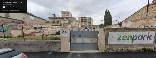 a parking meter in a parking lot next to a building with graffiti at cocon des arènes et parking in Nîmes