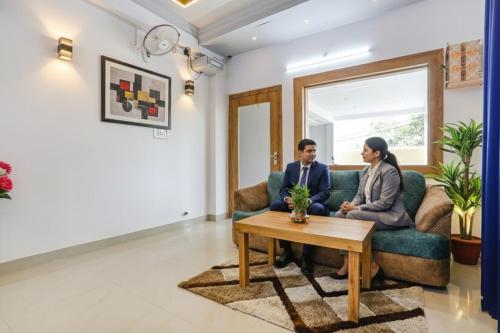 a man and woman sitting on a couch in a living room at FabHotel Sonnet Inns in Rānchī