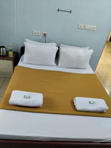 a bed with two towels sitting on top of it at Aruna homes -Lakshana- Thanjavur in Thanjāvūr