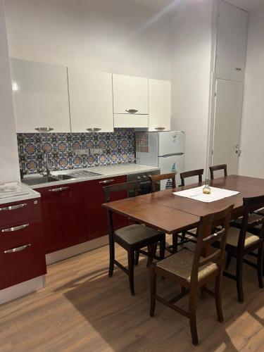 una cocina con mesa de madera y sillas. en Darsena Charming B&B by Villa Valentina Versilia, en Viareggio