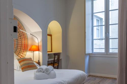 Le Barthou - T3 lumineux en centre-ville de Pau في بو: غرفة نوم بها سرير مع مناشف عليه