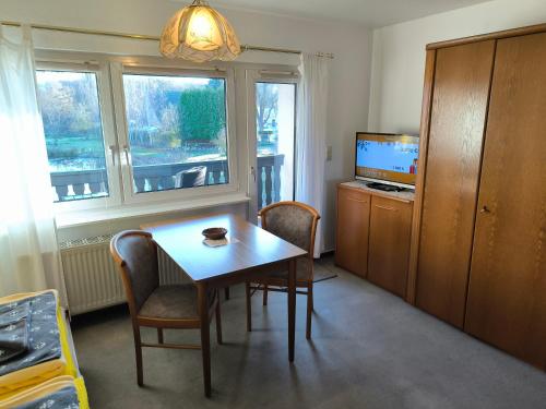 a room with a table and chairs and a television at Schwanensee App 04 in Göhren
