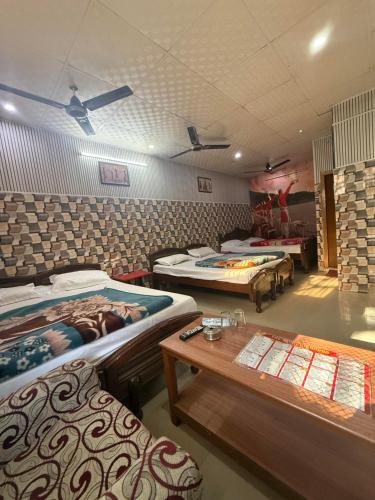 een kamer met vier bedden en een tafel erin bij Hotel Aditya Sheraton in Haridwār