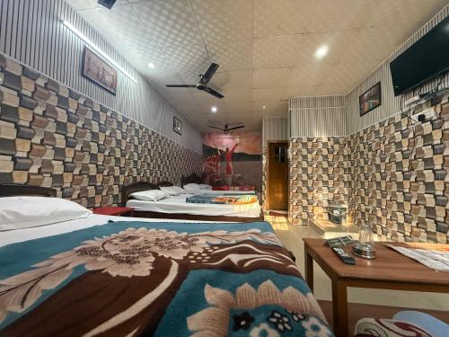 een hotelkamer met 2 bedden en een tafel en een bed sidx sidx bij Hotel Aditya Sheraton in Haridwār