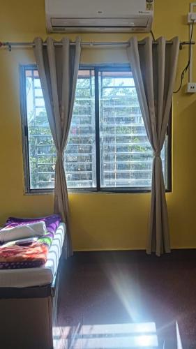 a room with a window with curtains and a bed at Trishan Hotel in Dhupguri
