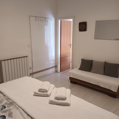 two beds in a room with a bed and a couch at Apartments Duras in Gruda