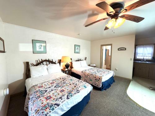 a bedroom with two beds and a ceiling fan at Parkview Lodge & Cabins in Newland