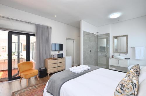 a bedroom with a large bed and a bathroom at Caracal 54 in Yzerfontein