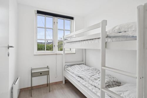 Feriehus 3007 في Nørre Lyngvig: غرفة نوم بها سريرين بطابقين ونافذة