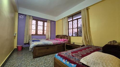Songden Homestay في Kurseong: غرفة نوم بسريرين ونوافذ