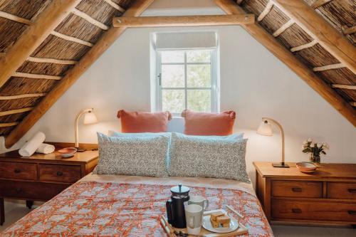 a bedroom with a bed with two lamps and a window at Finchlea Cottage in Stanford