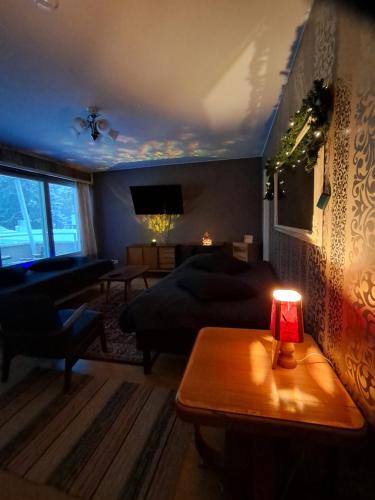 een woonkamer met een bank en een tafel met een lamp bij Warm Nest in Rovaniemi