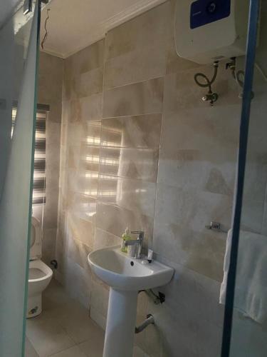 a bathroom with a sink and a toilet at Modex Hotel in Mama