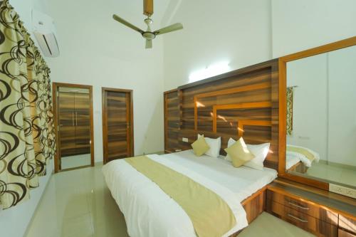 The Royal Villa في بانتشجانى: غرفة نوم بسرير كبير مع لوح رأس خشبي