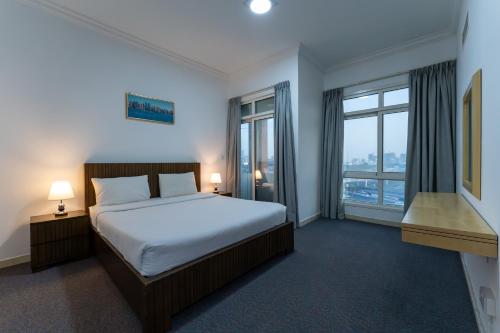 a bedroom with a bed and a large window at Havana Holiday Homes Oud Metha in Dubai