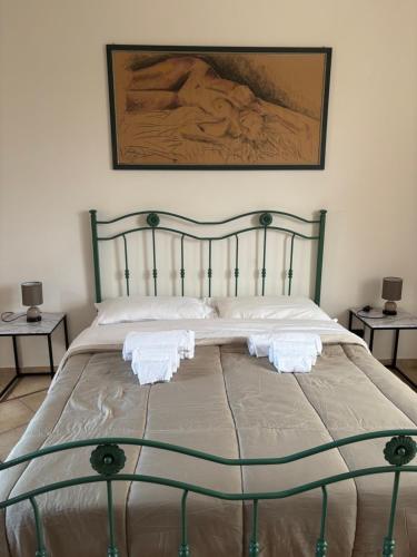 ein großes Bett mit zwei weißen Handtüchern drauf in der Unterkunft La Finestra sul Teatro Romano in Benevento