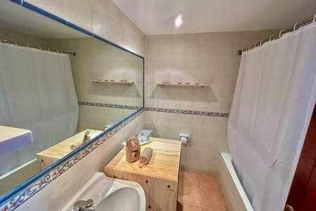 a bathroom with a sink and a mirror at SON BOU Apartamento en planta baja junto la playa in Son Bou