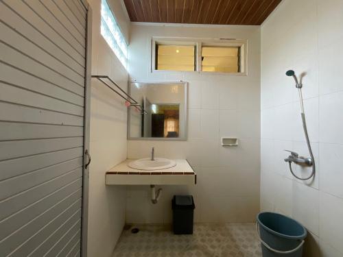 a bathroom with a sink and a mirror at Penginapan Mafir in Tuk Tuk