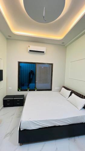 een slaapkamer met een groot wit bed en een plafond bij Rudrangan Suites Full Luxurious Villa Near Mahakaleshwar temple By AP villas and Resorts in Ujjain