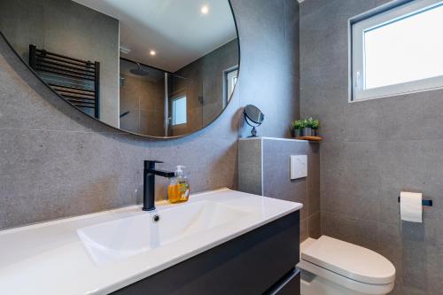 un bagno con un lavandino bianco e uno specchio di Beachhouse Renesse 2645 a Renesse