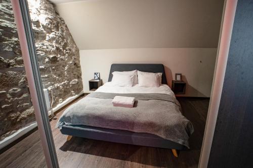 I&A Residence - Old Town في تالين: غرفة نوم بها سرير وجدار حجري كبير