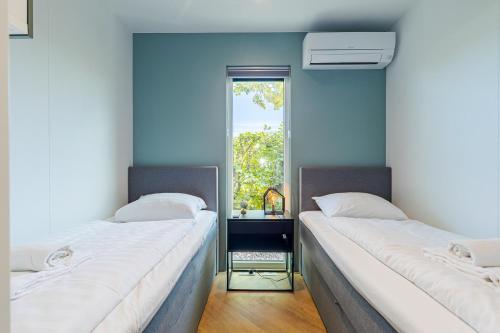 due letti in una stanza con finestra di Beachhouse Renesse 2645 a Renesse