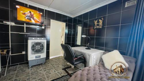 a room with a salon with a chair and a table at uPhondo Lodge in Bulawayo