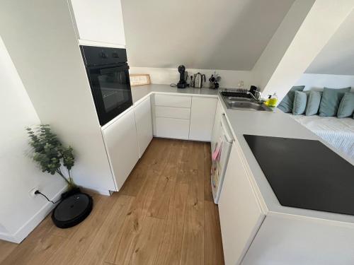 a small white kitchen with a sink and a stove at Magnifique logement indépendant avec sa place de parking in La Celle-sous-Gouzon