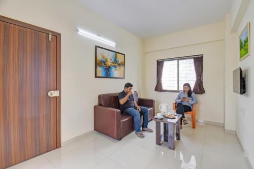 two people sitting in a waiting room in a hospital at FabHotel Paradise Inn Moshi in Pune