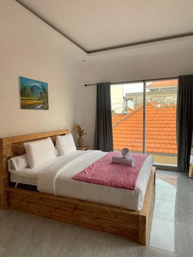 a bedroom with a bed and a large window at Villa cassia in Kerobokan