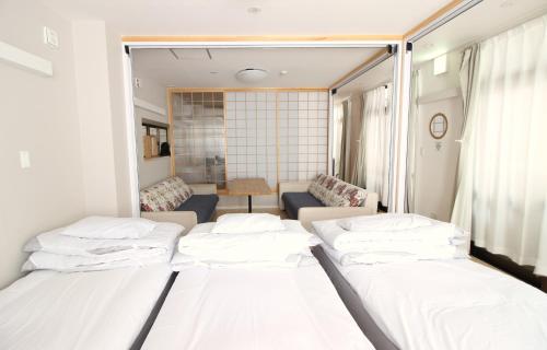 a room with three beds and a living room at Mcity in Wakasa in Naha