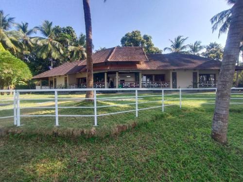 a white fence in front of a house at BharathaPuzha Resort in Kārakkād