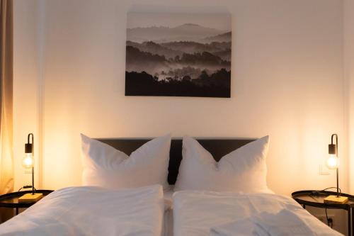 a bedroom with a bed with white sheets and pillows at Modern-Apartment am Schloss - Claycation in Marktbreit