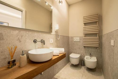 a bathroom with a sink and a toilet and a mirror at Be Your Home - Riviera Suites in Civitavecchia