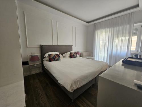 a white bedroom with a bed with two pillows at Be Your Home - Riviera Suites in Civitavecchia