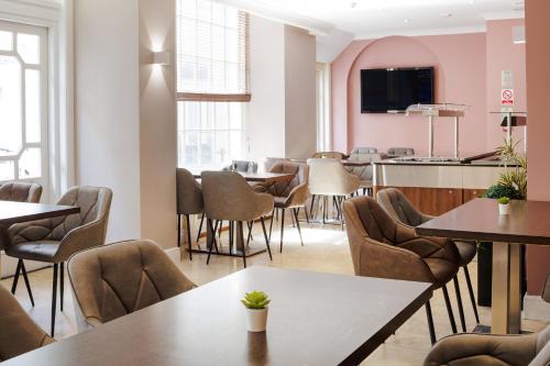 a restaurant with tables and chairs and a counter at Queens Park Premier London Hyde Park in London