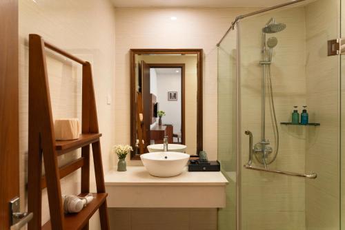 a bathroom with a sink and a shower at The Embassy Hotel Hanoi in Hanoi