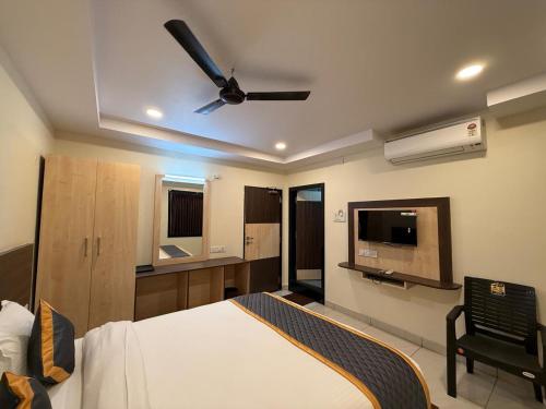 ein Schlafzimmer mit Bett und Deckenventilator in der Unterkunft DVR GRAND-AC Rooms in Visakhapatnam